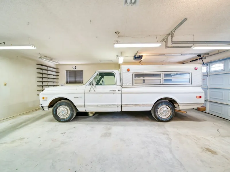 Classic pickup truck parked on a light gray garage floor in San Marcos