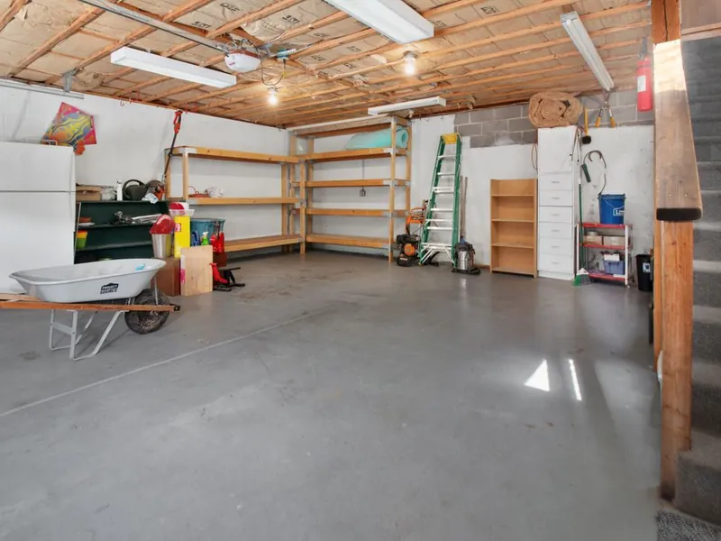 Two-car garage interior with storage shelving and concrete floor in San Marcos