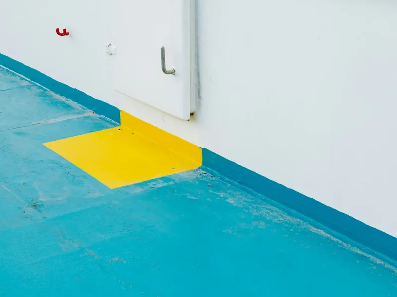 Glossy blue polyaspartic floor coating with yellow safety marking